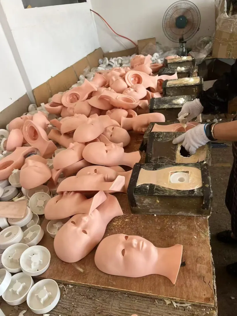 Demolded silicone mannequin faces beside the molds